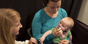 Baby being held while taking part in a study